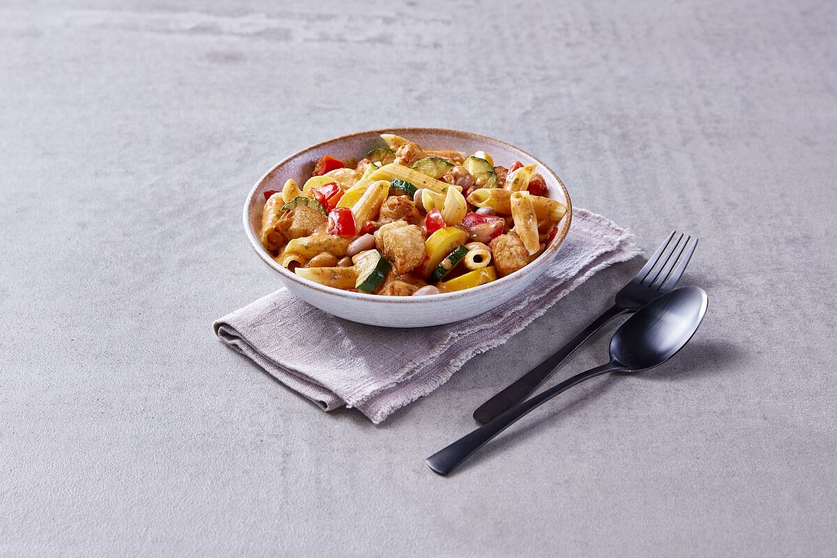 Mediterraner Genuss mit Proteinplus: Hühnerbrust und Penne treffen auf sonnengereifte Tomaten und frisch geriebenen Pecorino Romano DOP.