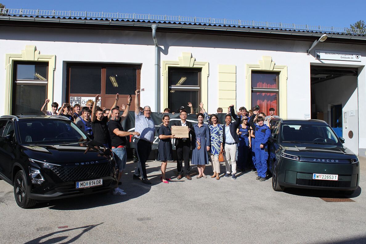 Vertreter: innen von Colmobil und der HTL Mödling mit Schüler: innen und den beiden neuen Ausbildungsfahrzeugen OMODA 5 HEV und JAECOO 5 BEV.