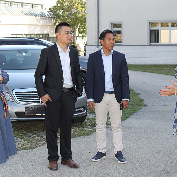 Vertreter: innen von Colmobil und der HTL Mödling mit Schüler: innen und den beiden neuen Ausbildungsfahrzeugen OMODA 5 HEV und JAECOO 5 BEV.