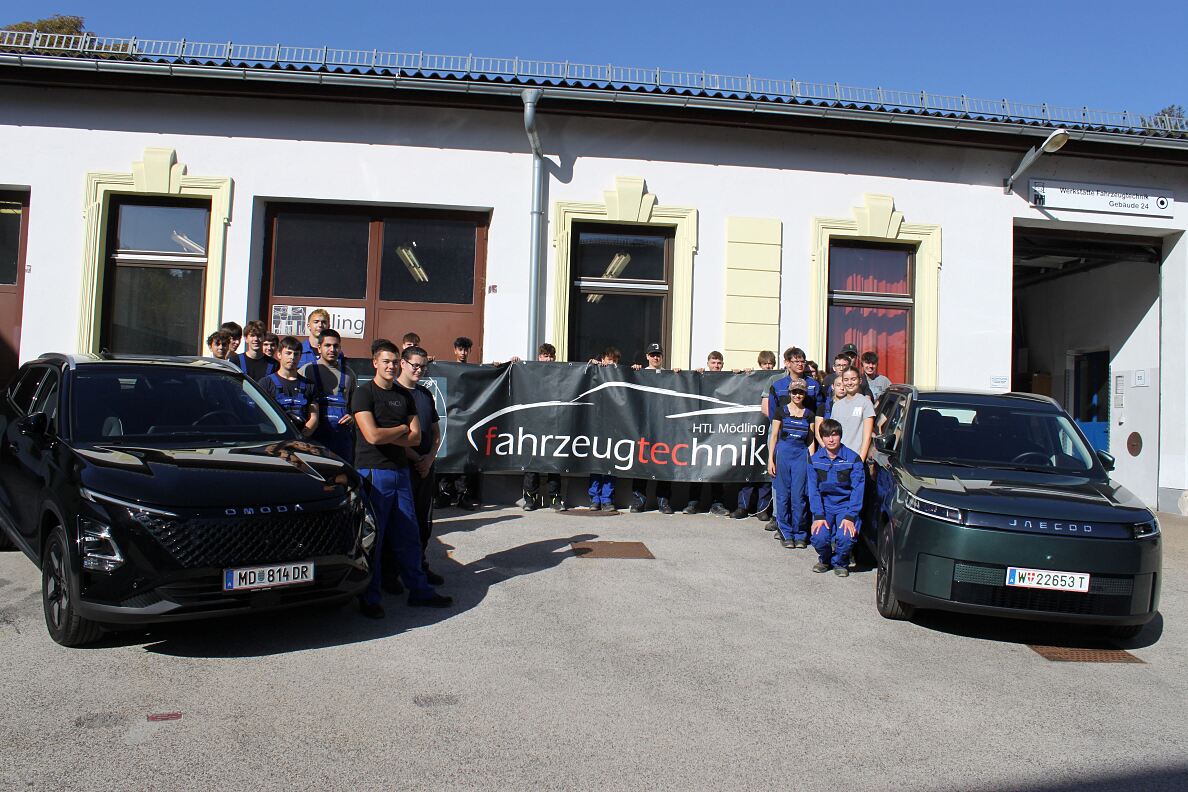 Vertreter: innen von Colmobil und der HTL Mödling mit Schüler: innen und den beiden neuen Ausbildungsfahrzeugen OMODA 5 HEV und JAECOO 5 BEV.