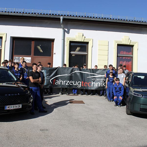 Vertreter: innen von Colmobil und der HTL Mödling mit Schüler: innen und den beiden neuen Ausbildungsfahrzeugen OMODA 5 HEV und JAECOO 5 BEV.