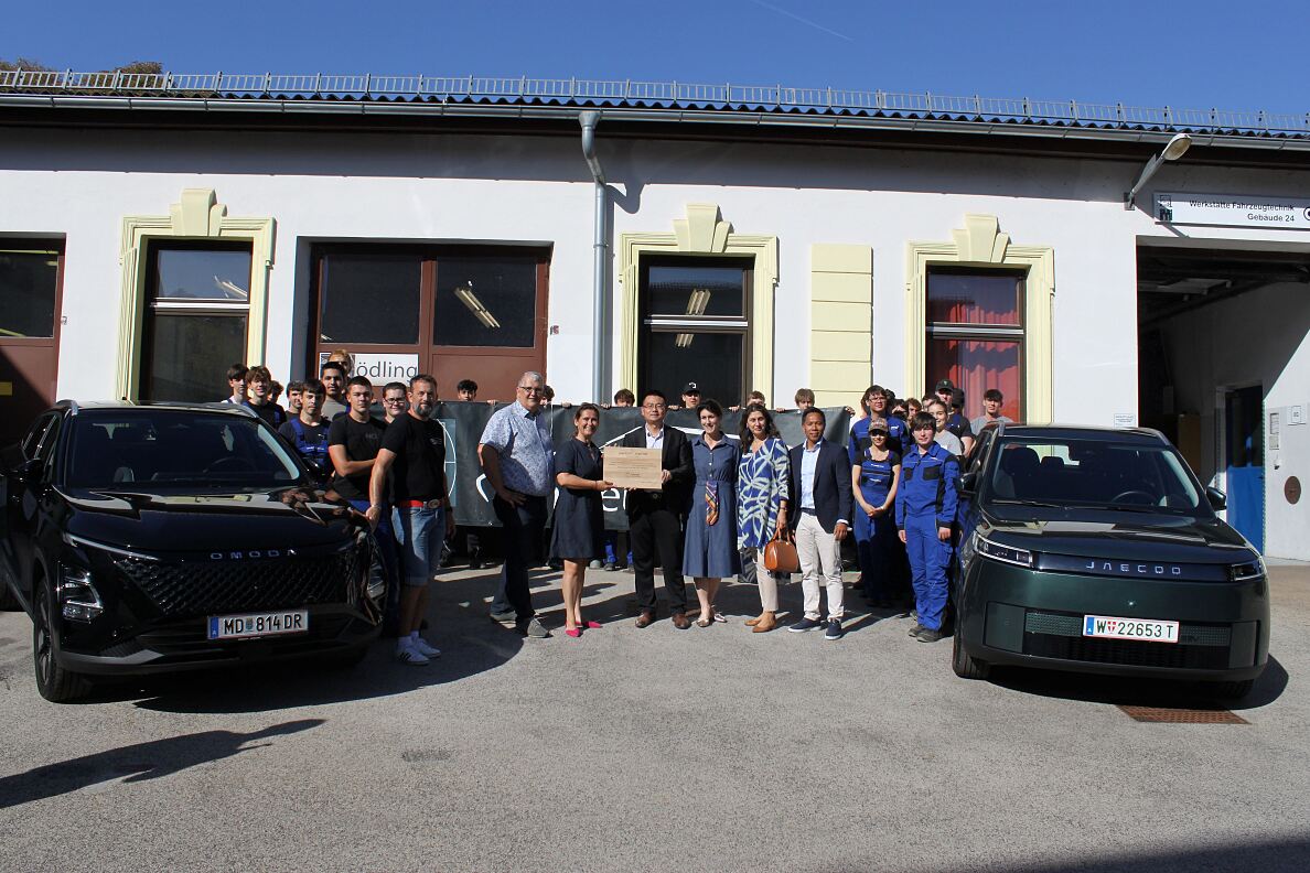 Vertreter: innen von Colmobil und der HTL Mödling mit Schüler: innen und den beiden neuen Ausbildungsfahrzeugen OMODA 5 HEV und JAECOO 5 BEV.